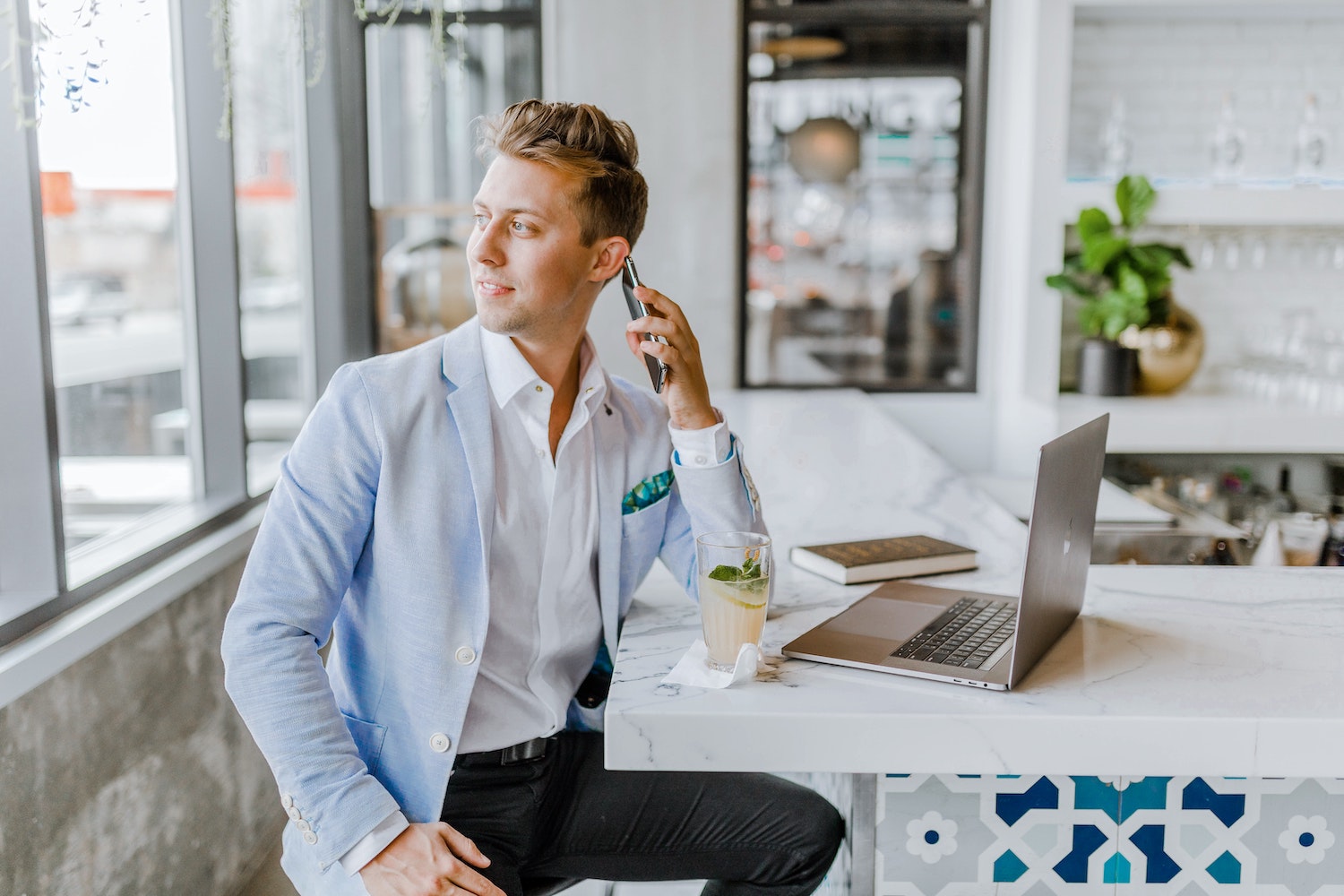 Business man speaking over the phone in front of a laptop